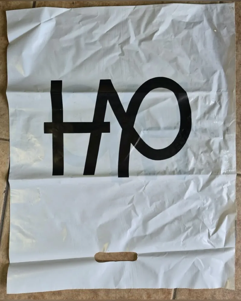 Bolsa troquelada blanca con asa cortada y logo impreso en negro
